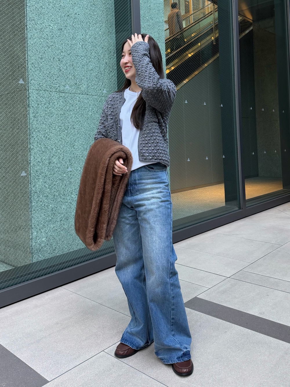 グレー系のニット/セーター、ブルー系のその他パンツ、ホワイト系のTシャツ/カットソーを着用したレディースの冬コーディネートの2枚目の写真