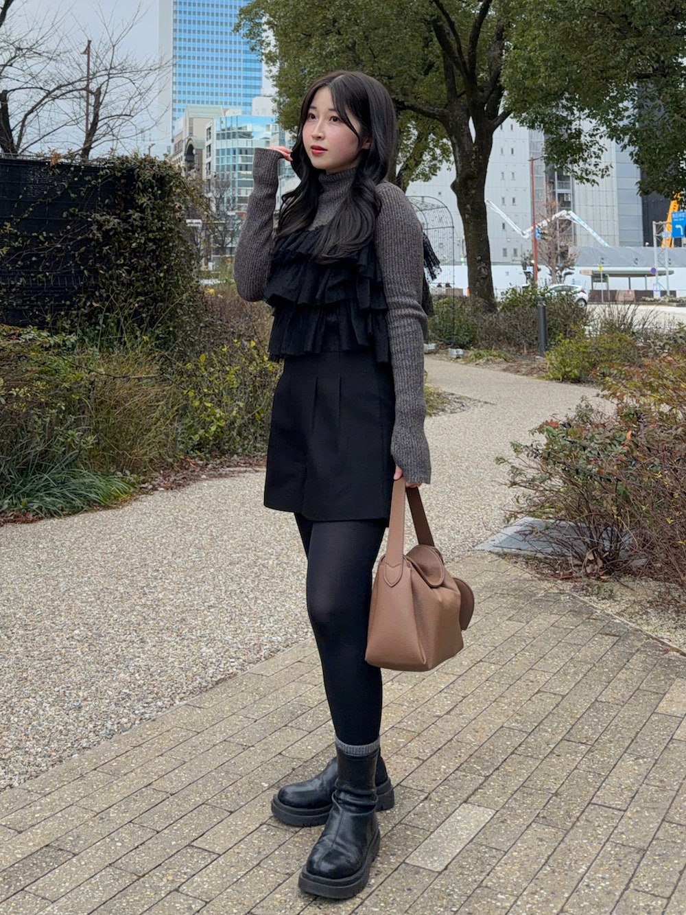 ブラック系のその他アウター、ブラック系のその他パンツ、ブラック系のブーツを着用したレディースの冬コーディネートの3枚目の写真
