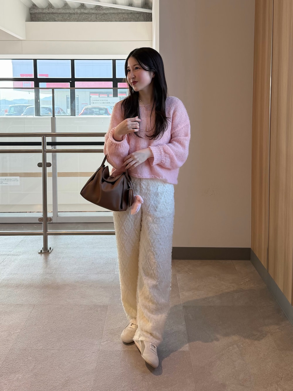 ピンク系のニット/セーター、ホワイト系のスニーカー、イエロー系のハンドバッグを着用したレディースの春コーディネートの3枚目の写真