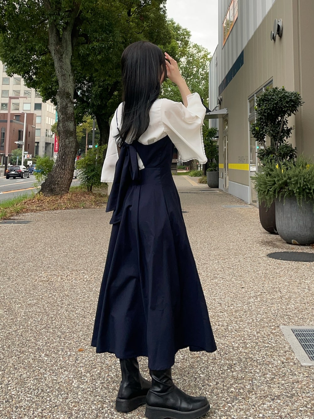 ブラック系のブーツ、ホワイト系のシャツ/ブラウス、ブルー系のワンピースを着用したレディースの秋コーディネートの3枚目の写真