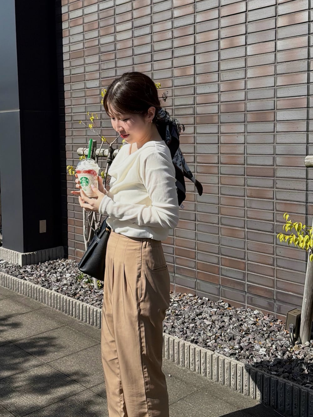 ホワイト系のキャミソール、ホワイト系のTシャツ/カットソー、ブラック系のショルダーバッグを着用したレディースの春コーディネートの3枚目の写真