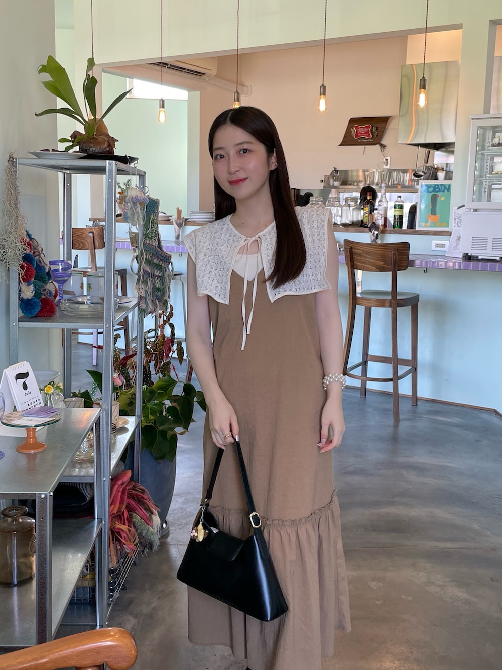 ホワイト系のシャツ/ブラウス、ブラック系のハンドバッグ、ブラウン系のワンピースを着用したレディースの夏コーディネートの3枚目の写真