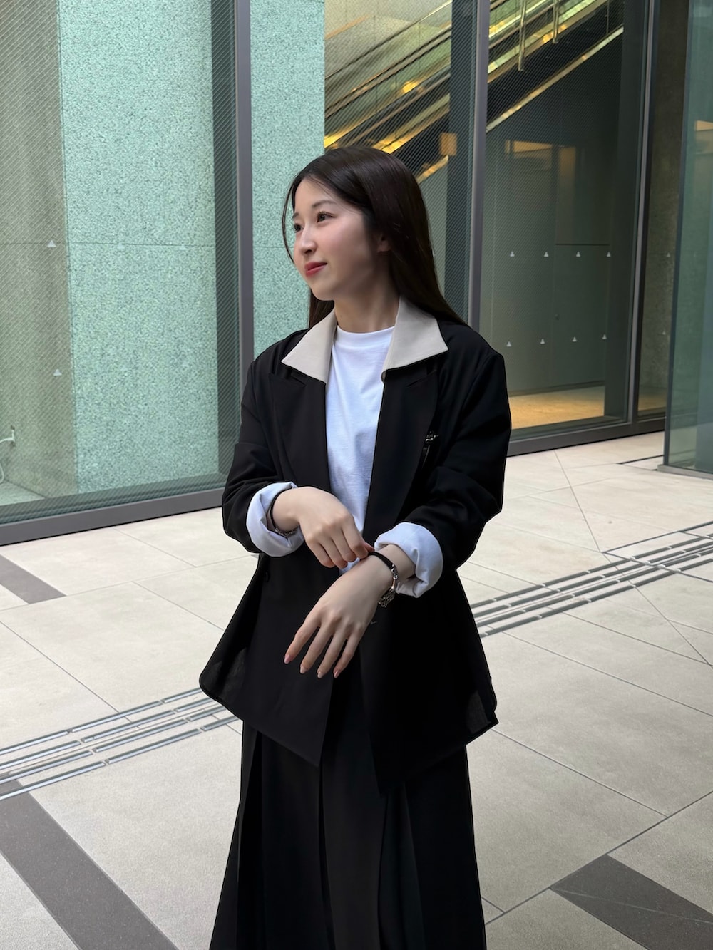 ホワイト系のTシャツ/カットソー、ブラック系のテーラードジャケット、ブラック系のスカートを着用したレディースの春コーディネートの3枚目の写真