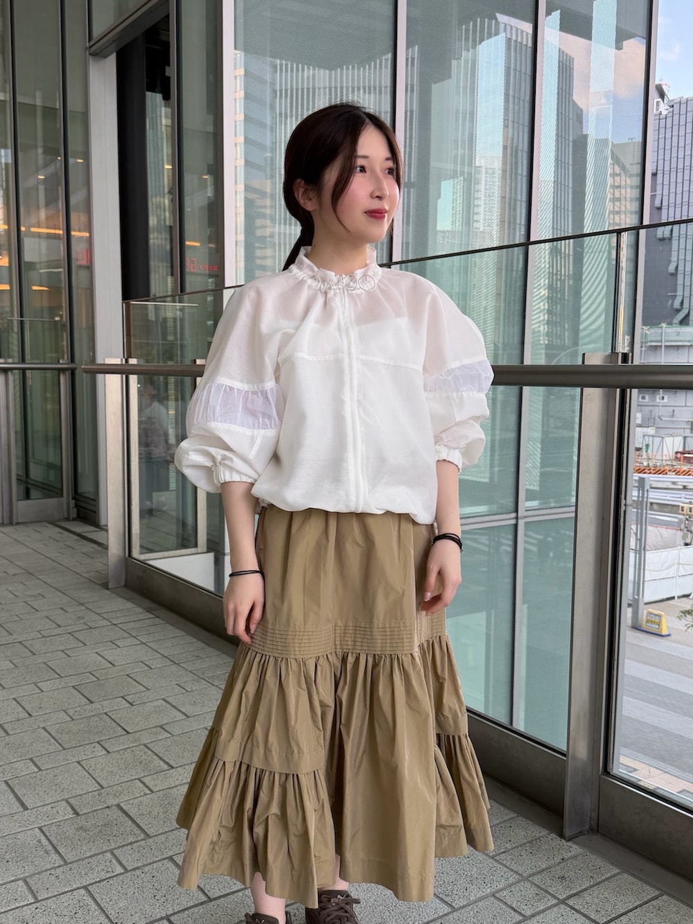 ホワイト系のキャミソール、ホワイト系のブルゾン、ベージュ系のスカートを着用したレディースの春コーディネートの4枚目の写真