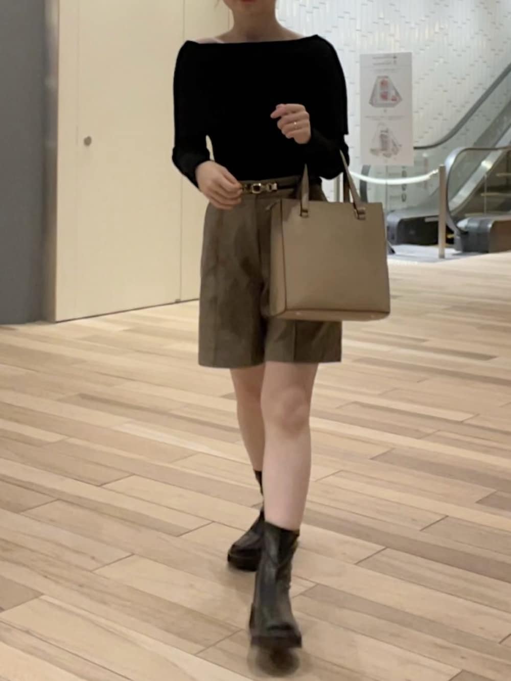 ブラック系のニット/セーター、ベージュ系のパンツ、ブラック系のブーツを着用したレディースの秋コーディネートの2枚目の写真