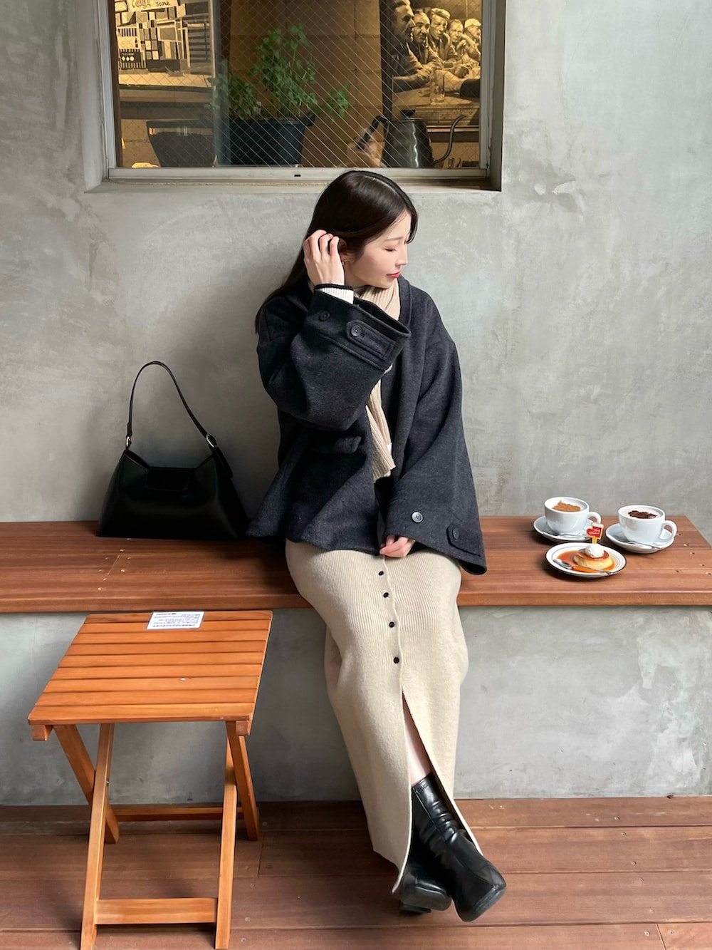 グレー系のその他アウター、ホワイト系のスカート、ブラック系のブーツを着用したレディースの冬コーディネートの2枚目の写真