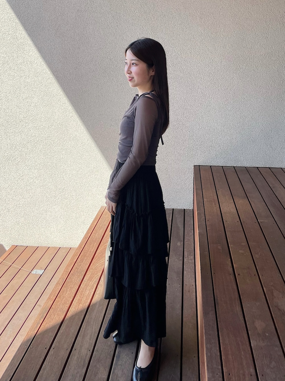 グレー系のTシャツ/カットソー、ブラック系のスカート、ブラック系のパンプスを着用したレディースの春コーディネートの3枚目の写真