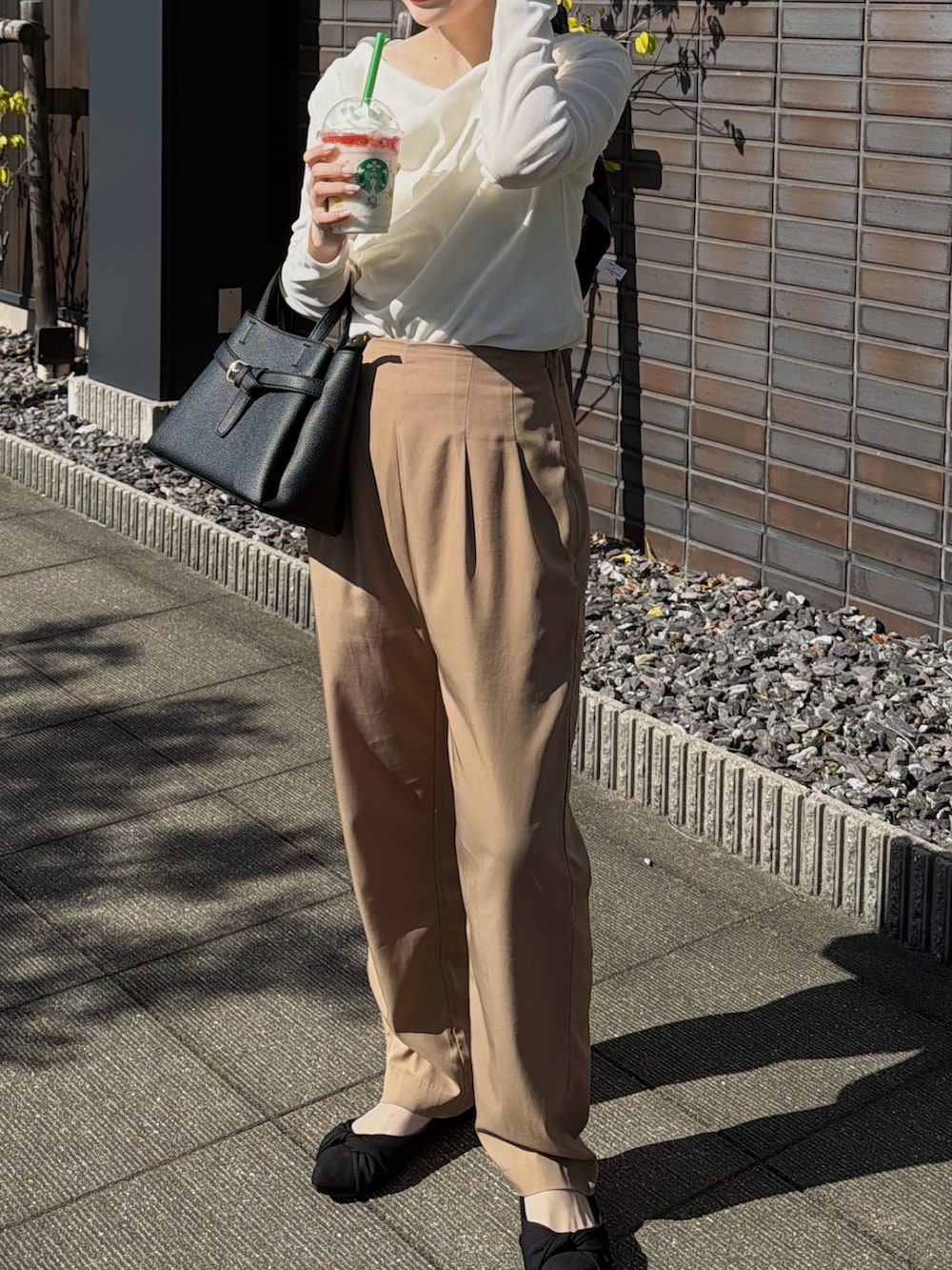 ホワイト系のキャミソール、ホワイト系のTシャツ/カットソー、ブラック系のショルダーバッグを着用したレディースの春コーディネートの2枚目の写真