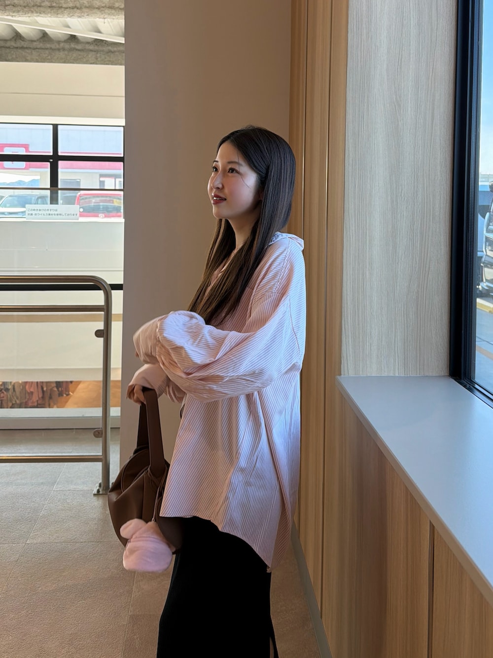 ホワイト系のスニーカー、ブラック系のスカート、イエロー系のハンドバッグを着用したレディースの春コーディネートの3枚目の写真