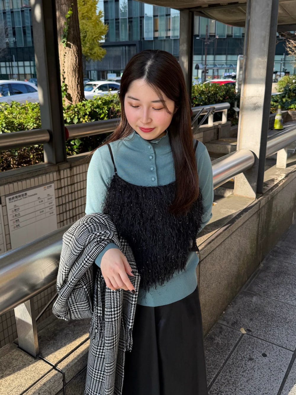 ブラック系のスカート、ブルー系のニット/セーター、ブラック系のシャツ/ブラウスを着用したレディースの冬コーディネートの3枚目の写真