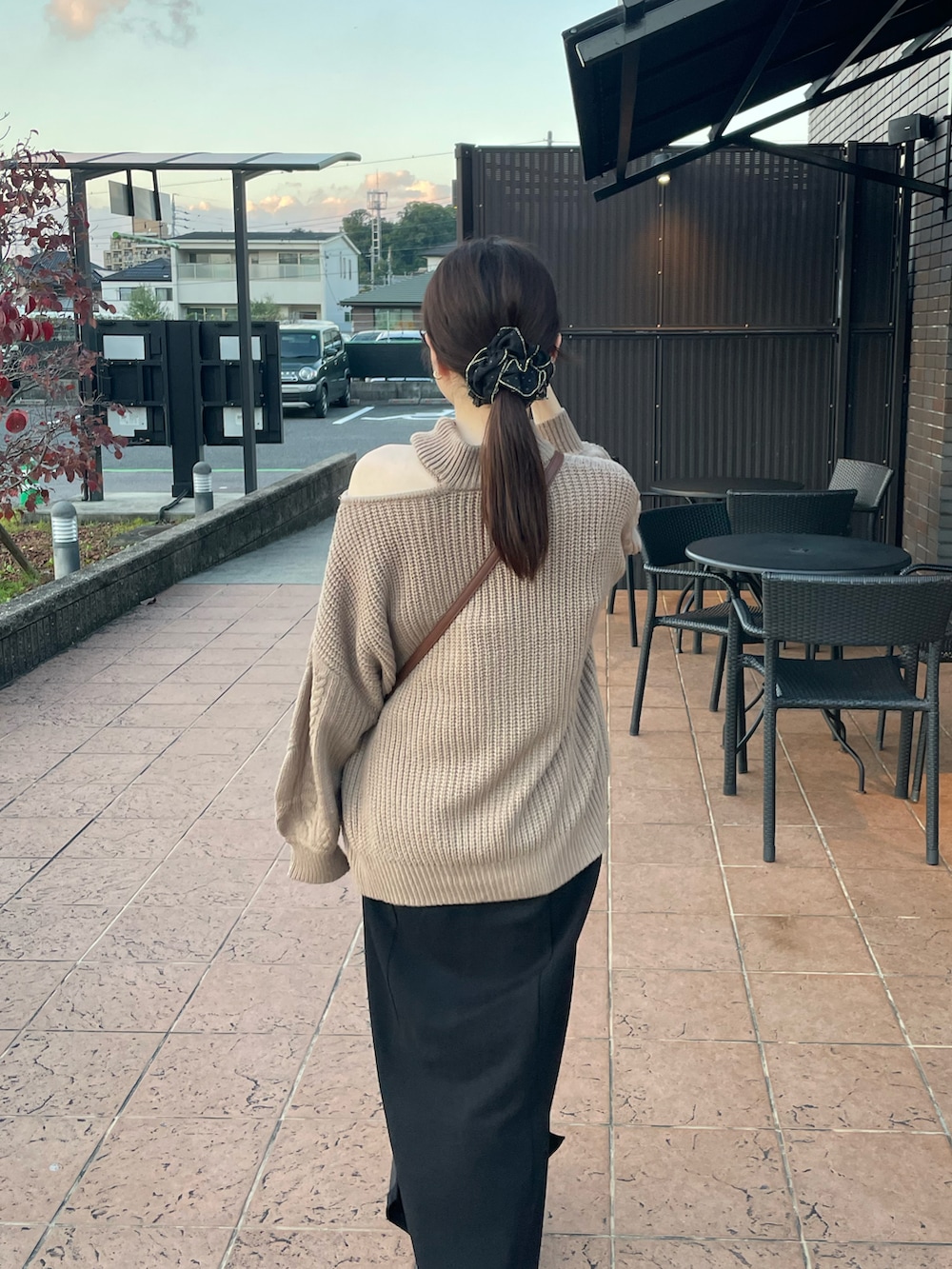 ブラウン系のニット/セーター、ブラック系のジャンパースカート、ブラック系のブーツを着用したレディースの秋コーディネートの2枚目の写真