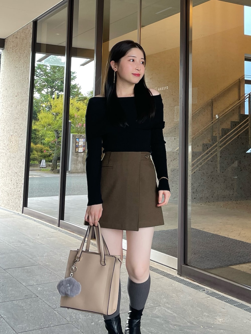 ブラック系のブーツ、ブラウン系のスカート、ブラック系のニット/セーターを着用したレディースの秋コーディネートの3枚目の写真