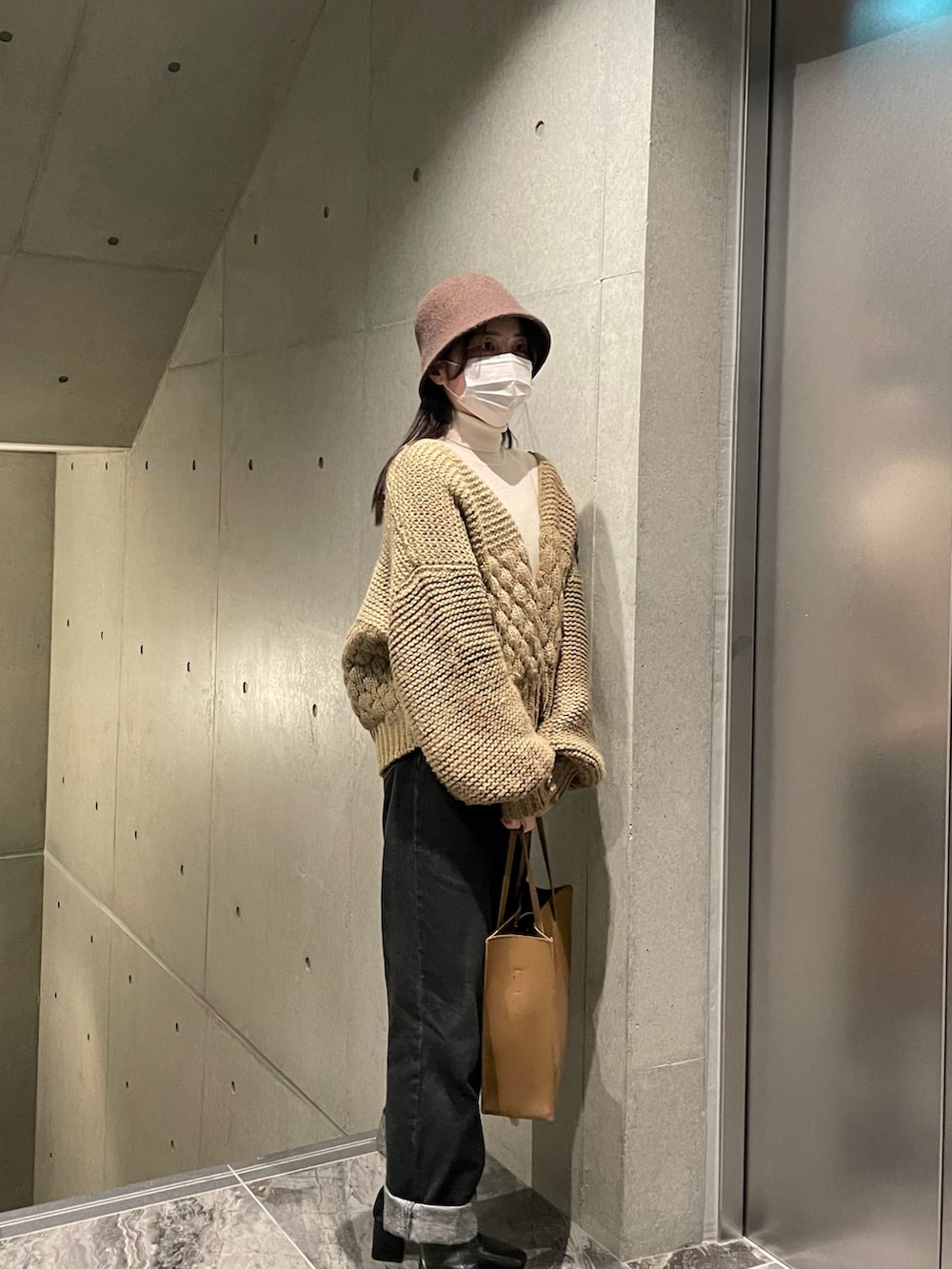 ホワイト系のニット/セーター、ベージュ系のカーディガン/ボレロ、ブラック系のデニムパンツを着用したレディースの秋コーディネートの3枚目の写真