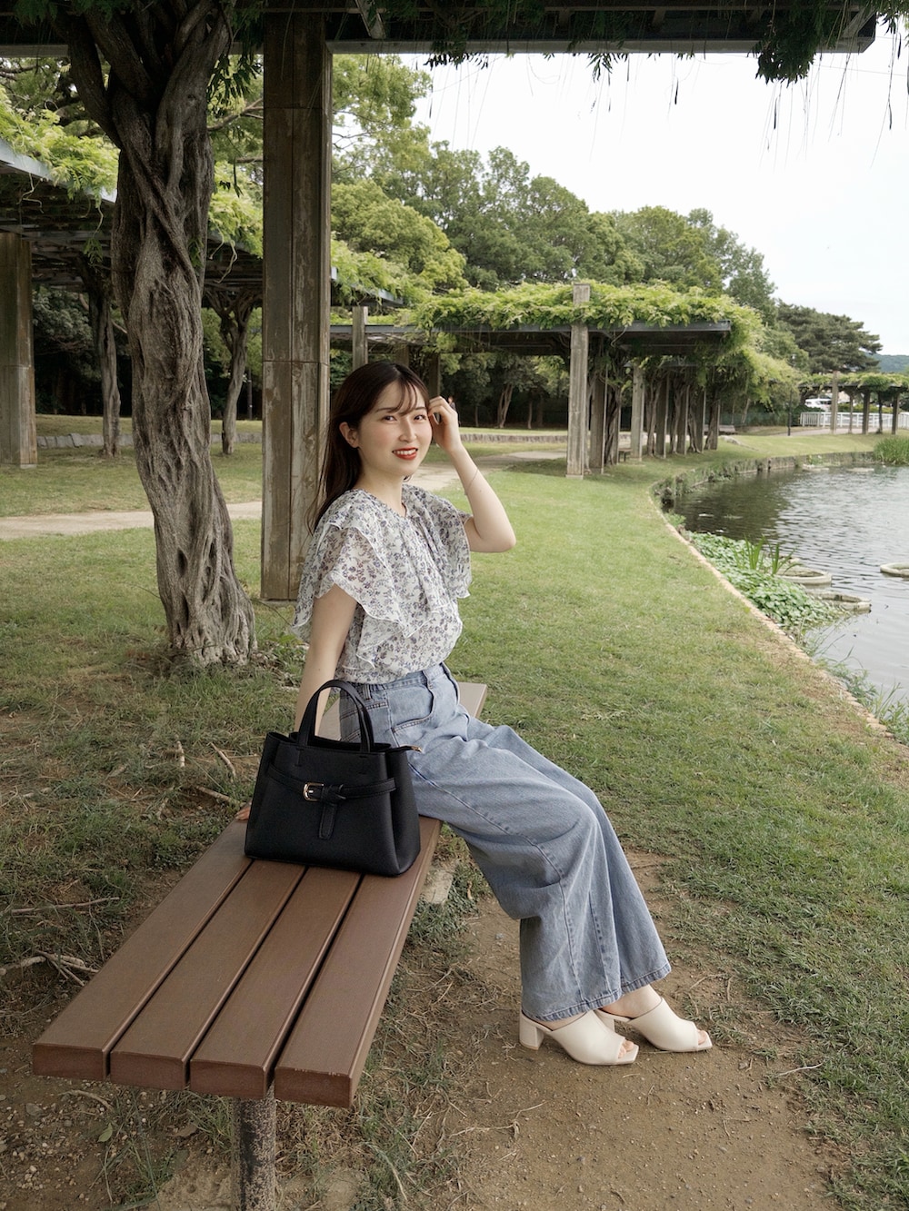 ホワイト系のサンダル、ホワイト系のシャツ/ブラウス、ブルー系のデニムパンツを着用したレディースの春コーディネートの3枚目の写真