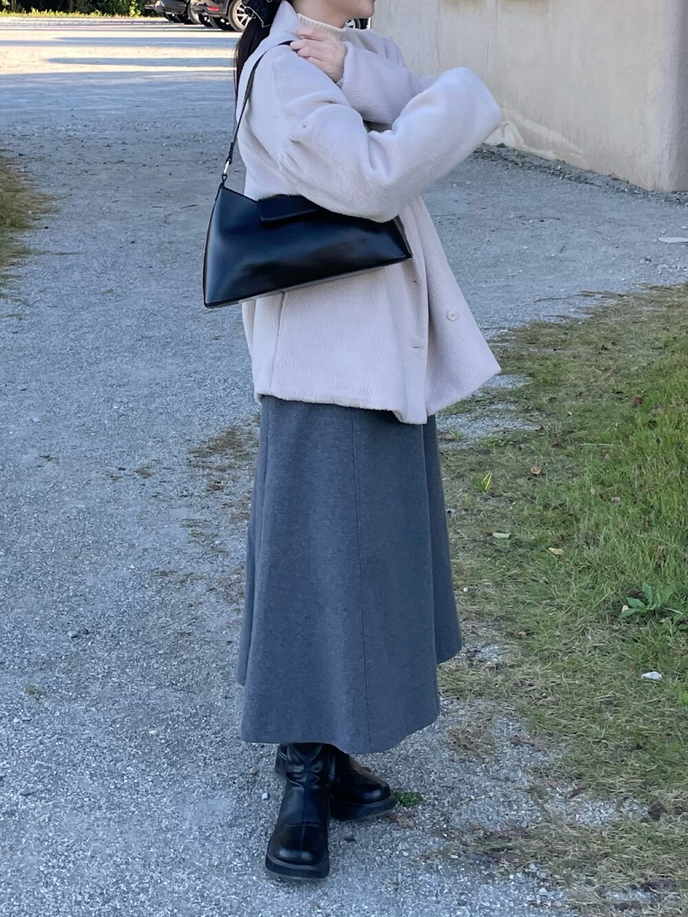 ホワイト系のニット/セーター、グレー系のワンピース、ブラック系のブーツを着用したレディースの秋コーディネートの2枚目の写真