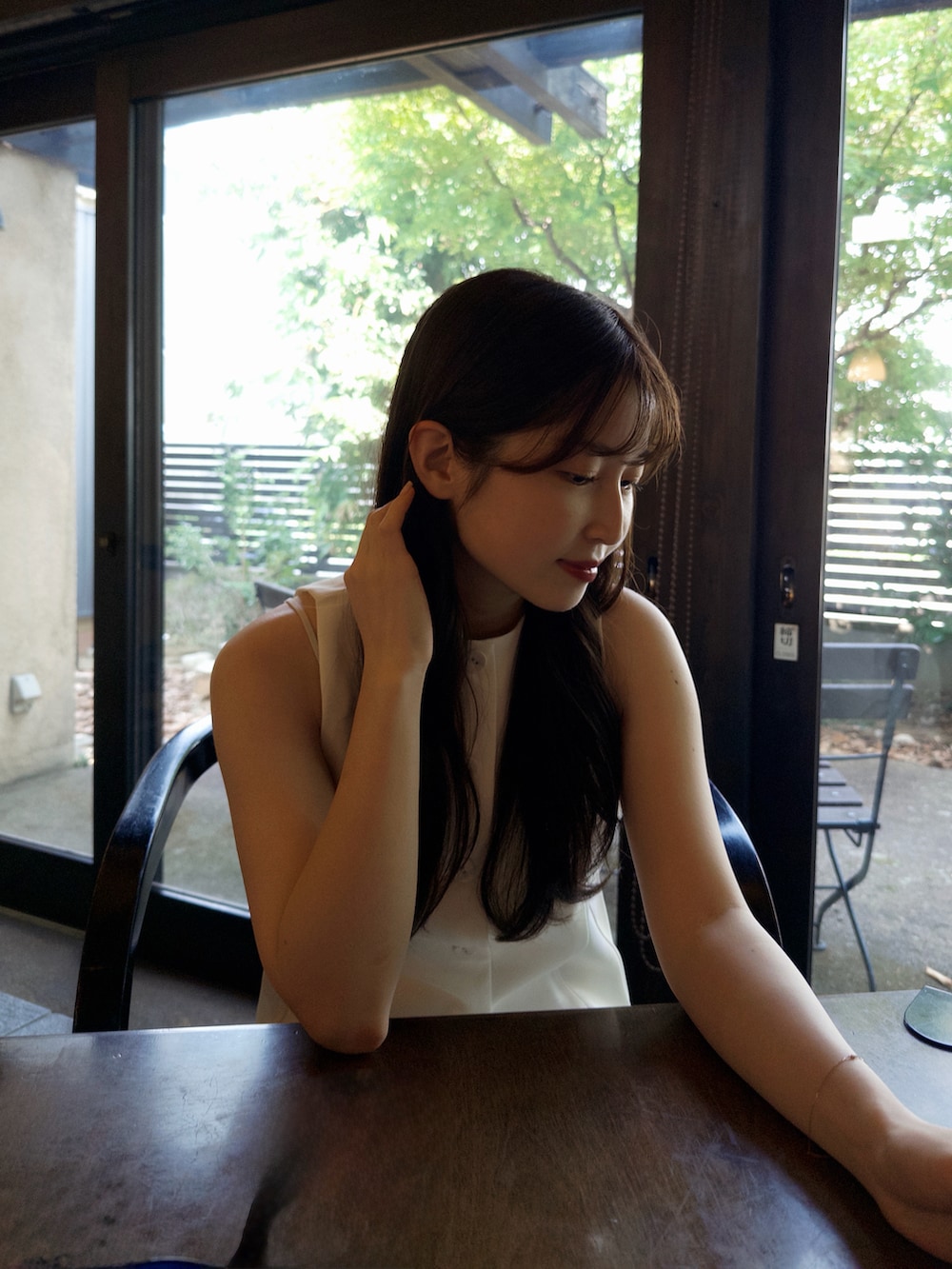 ホワイト系のベスト、ベージュ系のトートバッグ、ホワイト系のサンダルを着用したレディースの夏コーディネートの3枚目の写真
