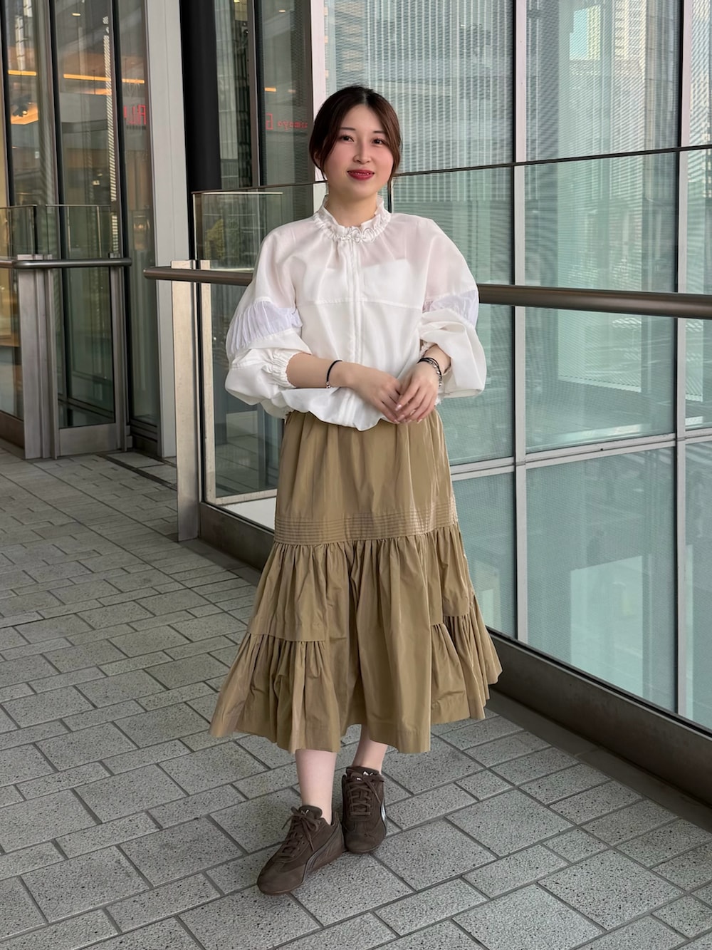 ホワイト系のキャミソール、ホワイト系のブルゾン、ベージュ系のスカートを着用したレディースの春コーディネートの5枚目の写真
