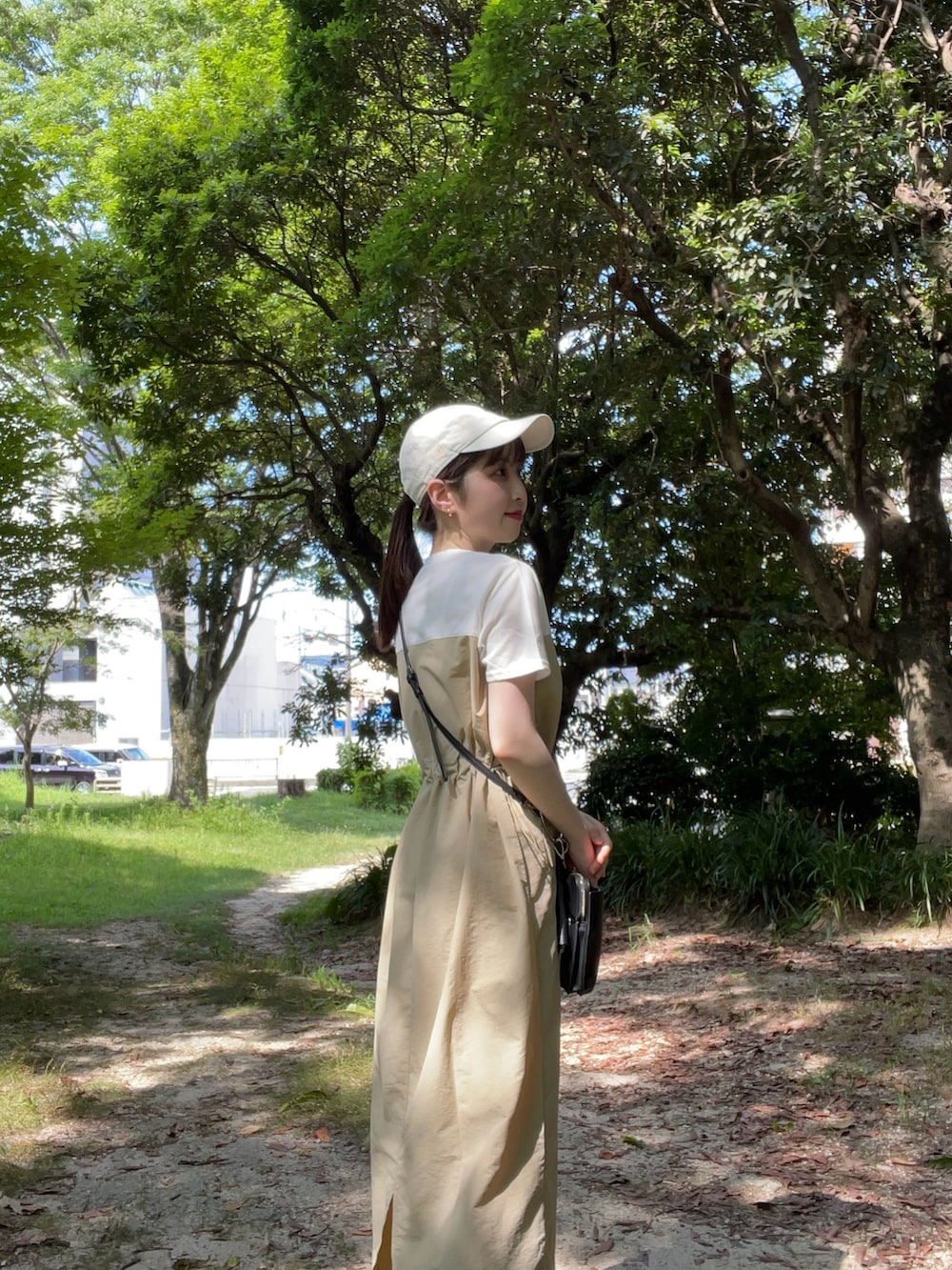 ベージュ系のワンピース、ブラック系のサンダル、ブラック系のハンドバッグを着用したレディースの夏コーディネートの4枚目の写真