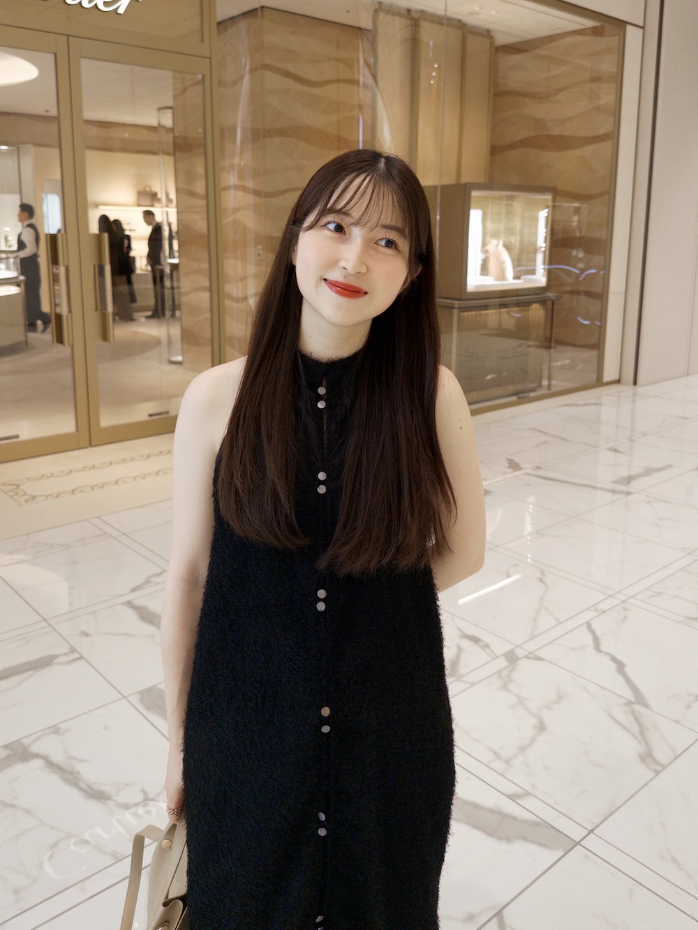 ベージュ系のトートバッグ、ブルー系のパンツ、ブラック系のワンピース/ドレスを着用したレディースの夏コーディネートの3枚目の写真