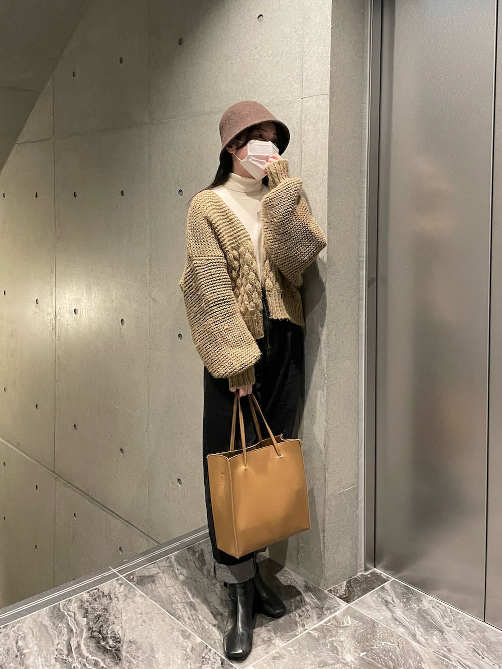 ホワイト系のニット/セーター、ベージュ系のカーディガン/ボレロ、ブラック系のデニムパンツを着用したレディースの秋コーディネートの2枚目の写真