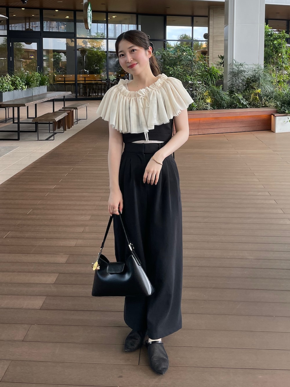 ブラック系のハンドバッグ、ブラック系のその他パンツ、ブラック系のトップスを着用したレディースの夏コーディネートの3枚目の写真