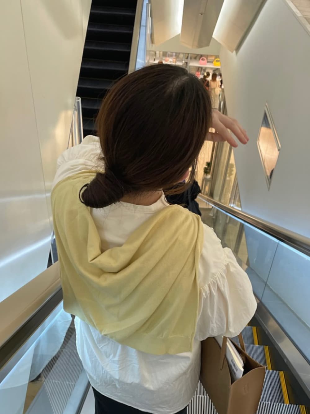 ホワイト系のシャツ/ブラウス、イエロー系のカーディガン/ボレロ、ブラック系のスカートを着用したレディースの春コーディネートの3枚目の写真