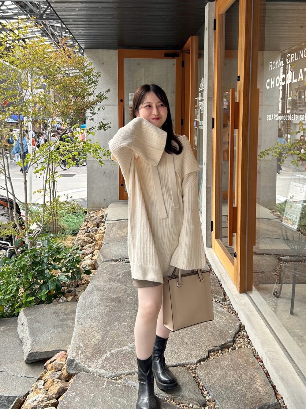 ホワイト系のニット/セーター、ベージュ系のパンツ、ブラック系のブーツを着用したレディースの秋コーディネートの2枚目の写真