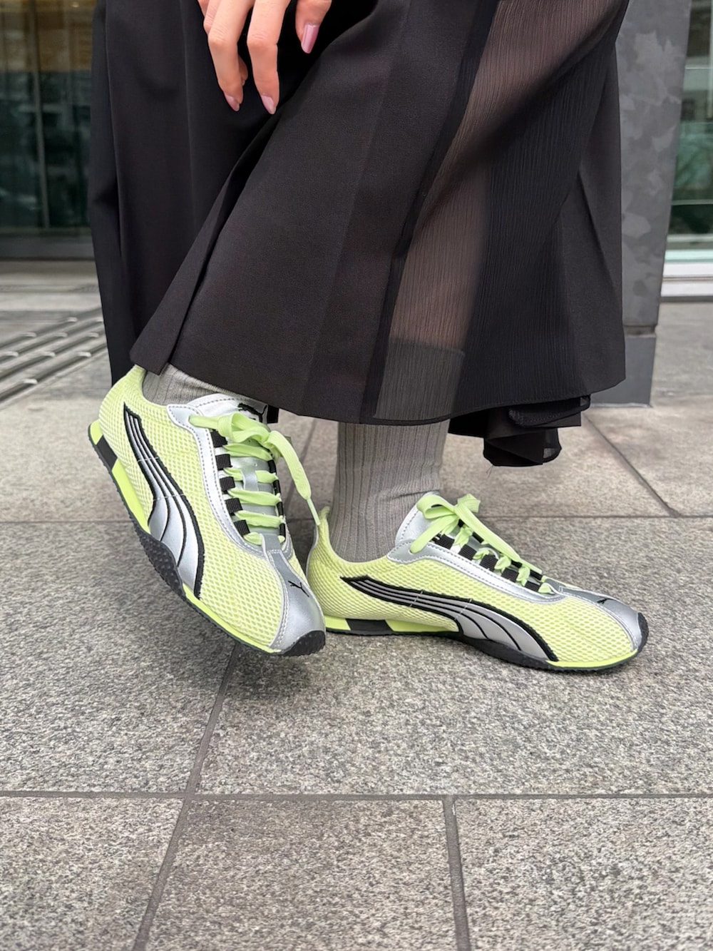 ホワイト系のTシャツ/カットソー、ブラック系のスカート、グレー系のカーディガン/ボレロを着用したレディースの春コーディネートの5枚目の写真