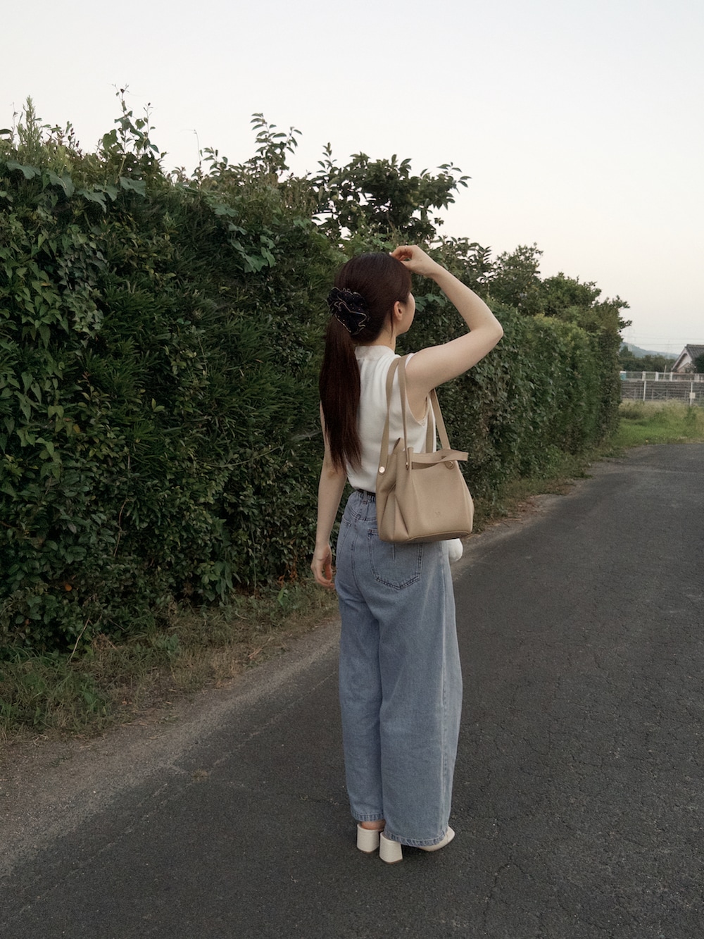 ホワイト系のニット/セーター、ブルー系のデニムパンツ、ホワイト系のサンダルを着用したレディースの夏コーディネートの3枚目の写真