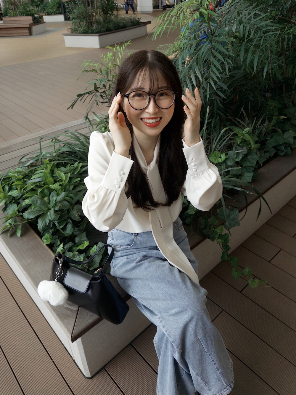 ホワイト系のシャツ/ブラウス、ブルー系のデニムパンツ、ブラック系のハンドバッグを着用したレディースの夏コーディネートの4枚目の写真