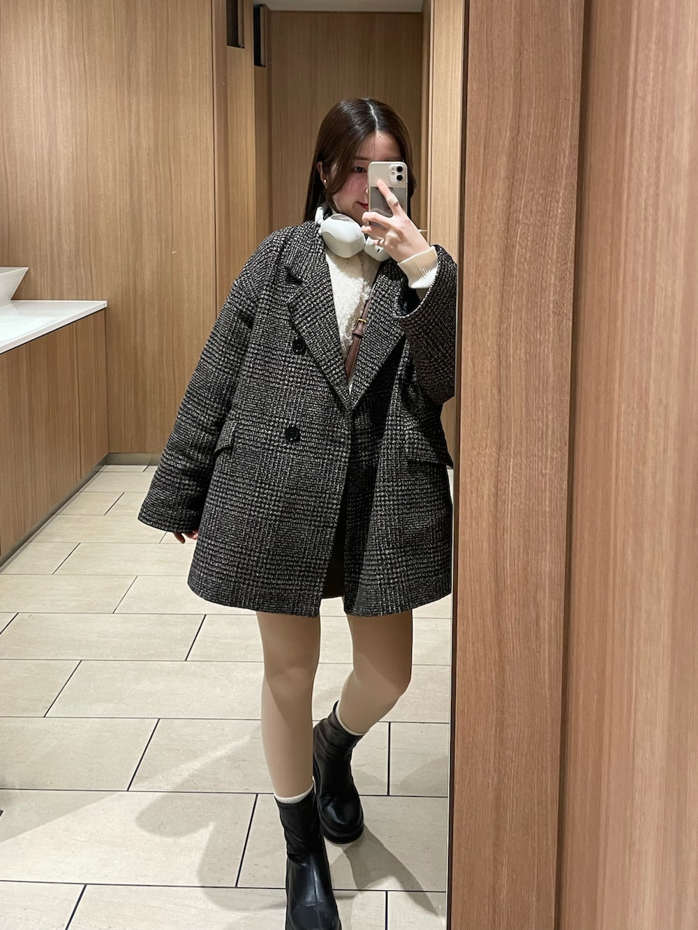 ホワイト系のニット/セーター、ホワイト系のシャツ/ブラウス、ブラウン系のスカートを着用したレディースの冬コーディネートの2枚目の写真