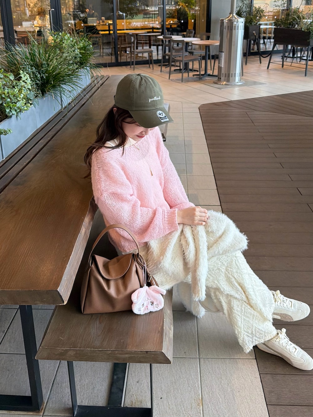 ピンク系のニット/セーター、ホワイト系のスニーカー、イエロー系のハンドバッグを着用したレディースの春コーディネートの2枚目の写真