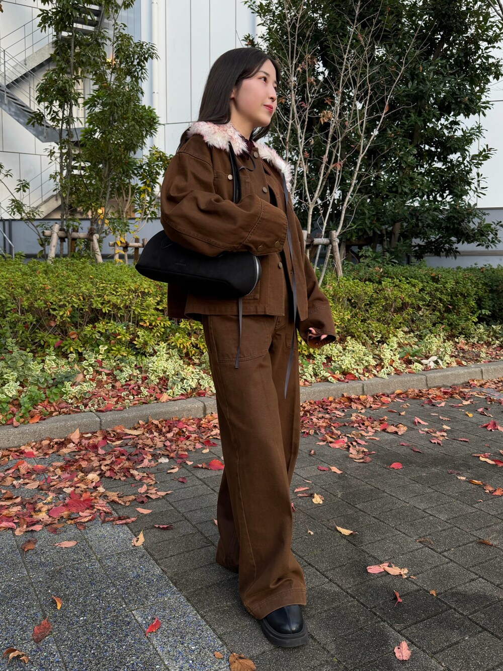 ブラック系のニット/セーター、ブラウン系のテーラードジャケット、ブラウン系のその他パンツを着用したレディースの秋コーディネートの5枚目の写真