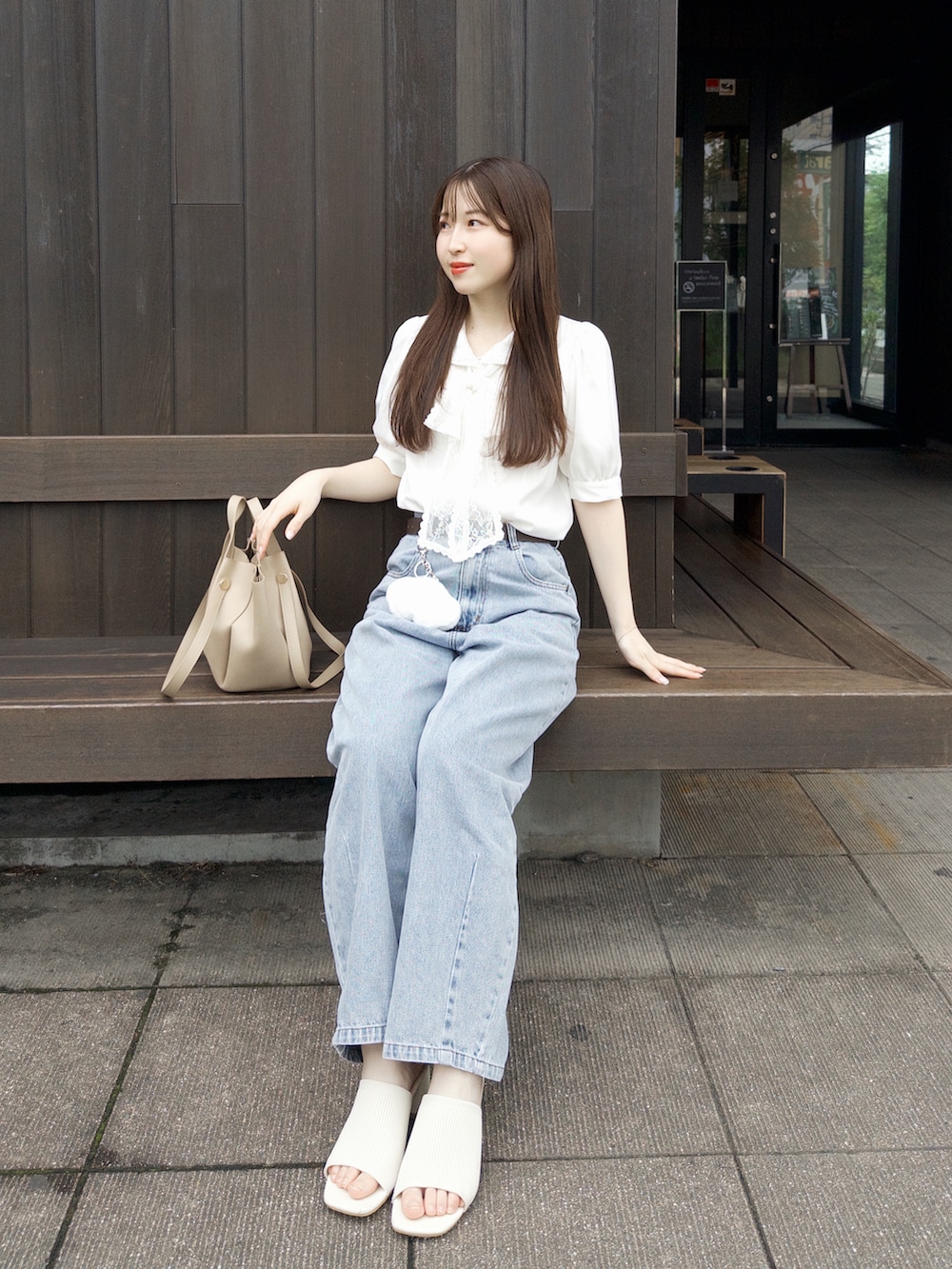 ホワイト系のシャツ/ブラウス、ブルー系のデニムパンツ、ベージュ系のトートバッグを着用したレディースの夏コーディネートの2枚目の写真