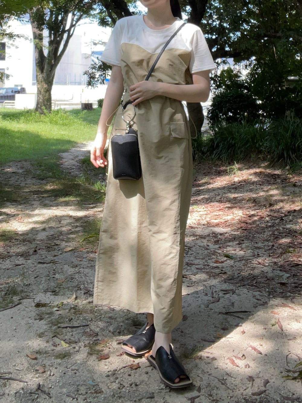 ベージュ系のワンピース、ブラック系のサンダル、ブラック系のハンドバッグを着用したレディースの夏コーディネートの5枚目の写真