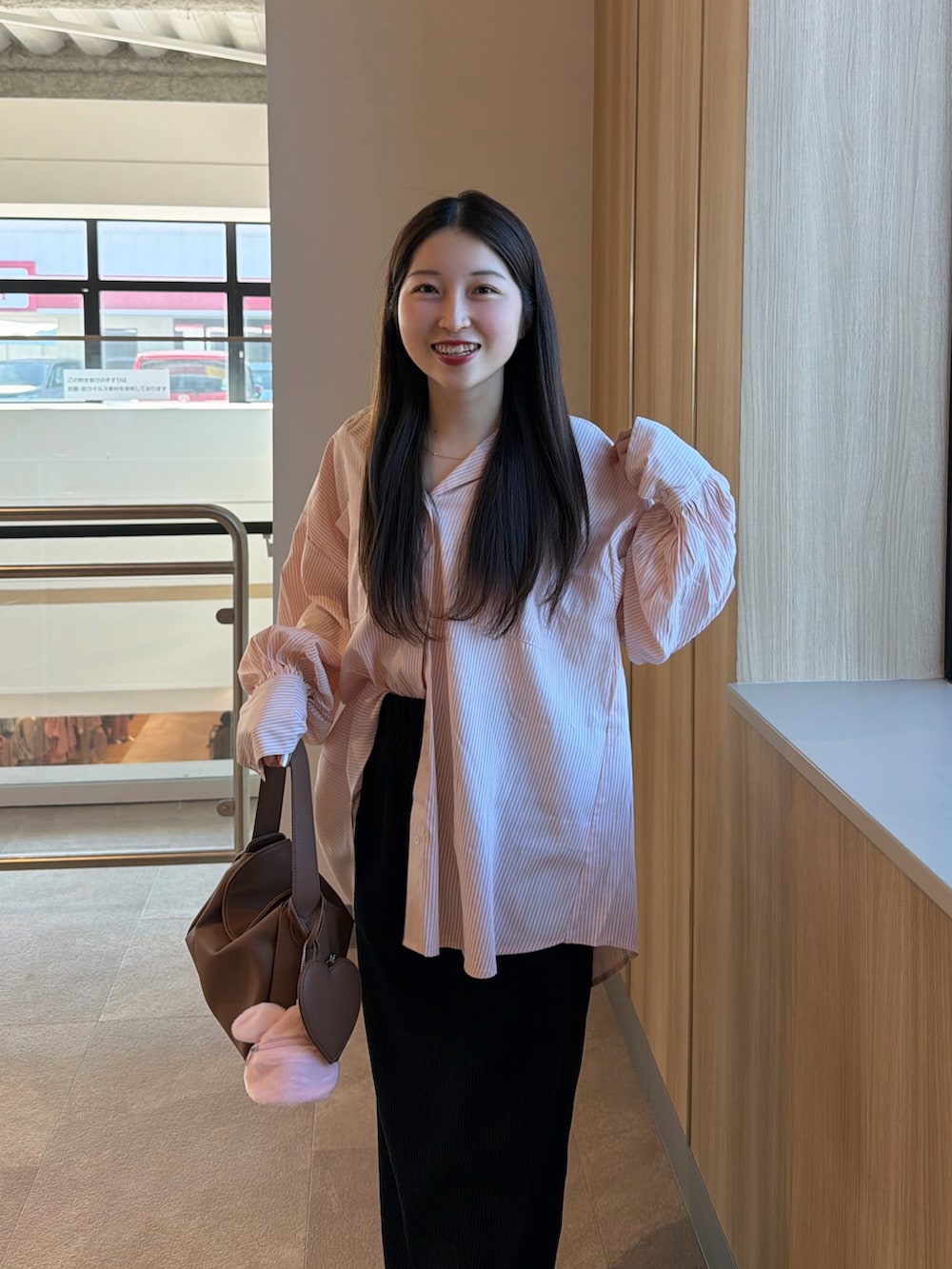 ホワイト系のスニーカー、ブラック系のスカート、イエロー系のハンドバッグを着用したレディースの春コーディネートの4枚目の写真