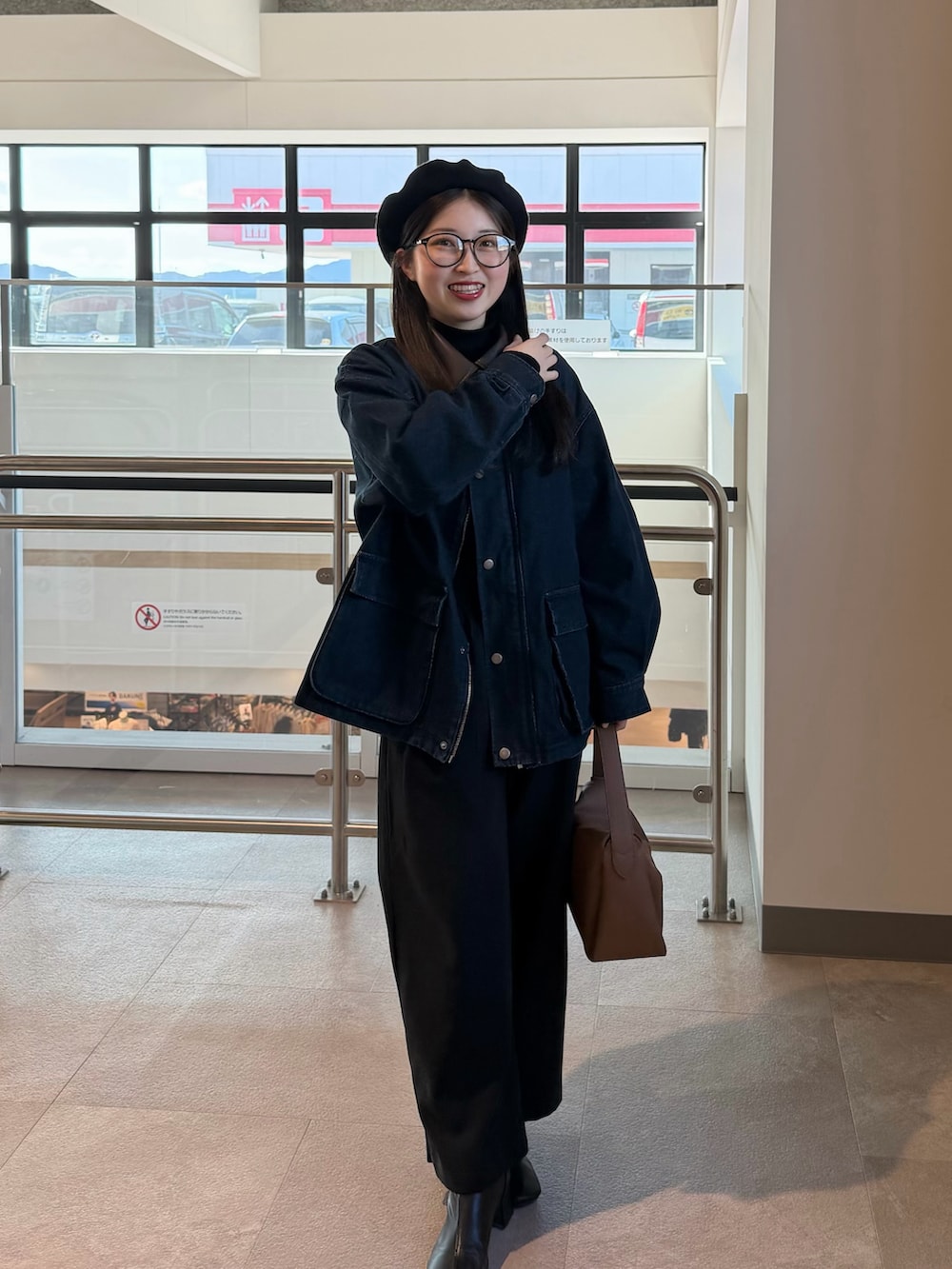 ブラック系のニット/セーター、ブラック系のブーツ、ブルー系のデニムジャケットを着用したレディースの冬コーディネートの3枚目の写真