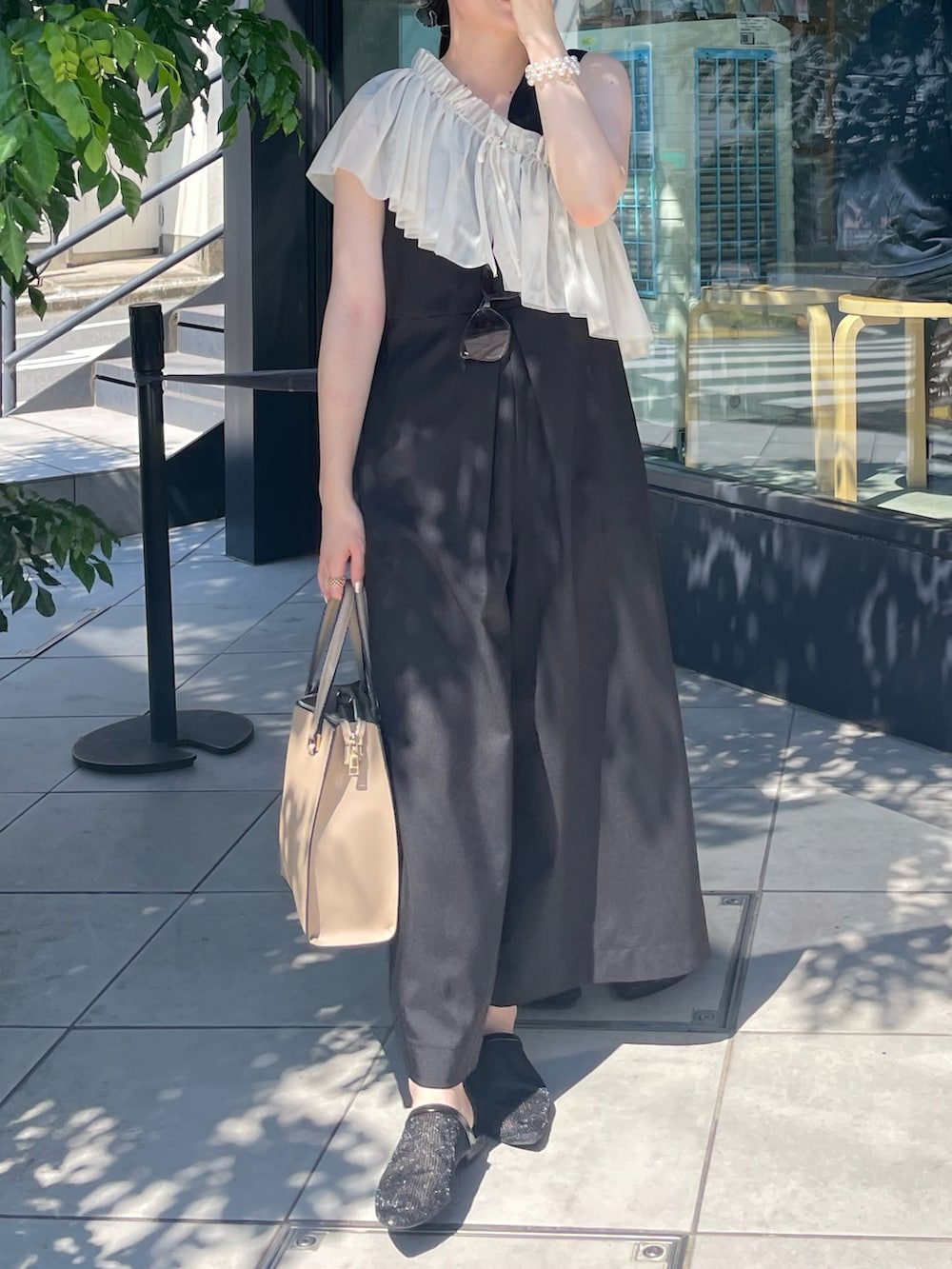 ブラック系のオールインワン・サロペット、ベージュ系のバッグ、ブラック系のシューズを着用したレディースの夏コーディネートの3枚目の写真