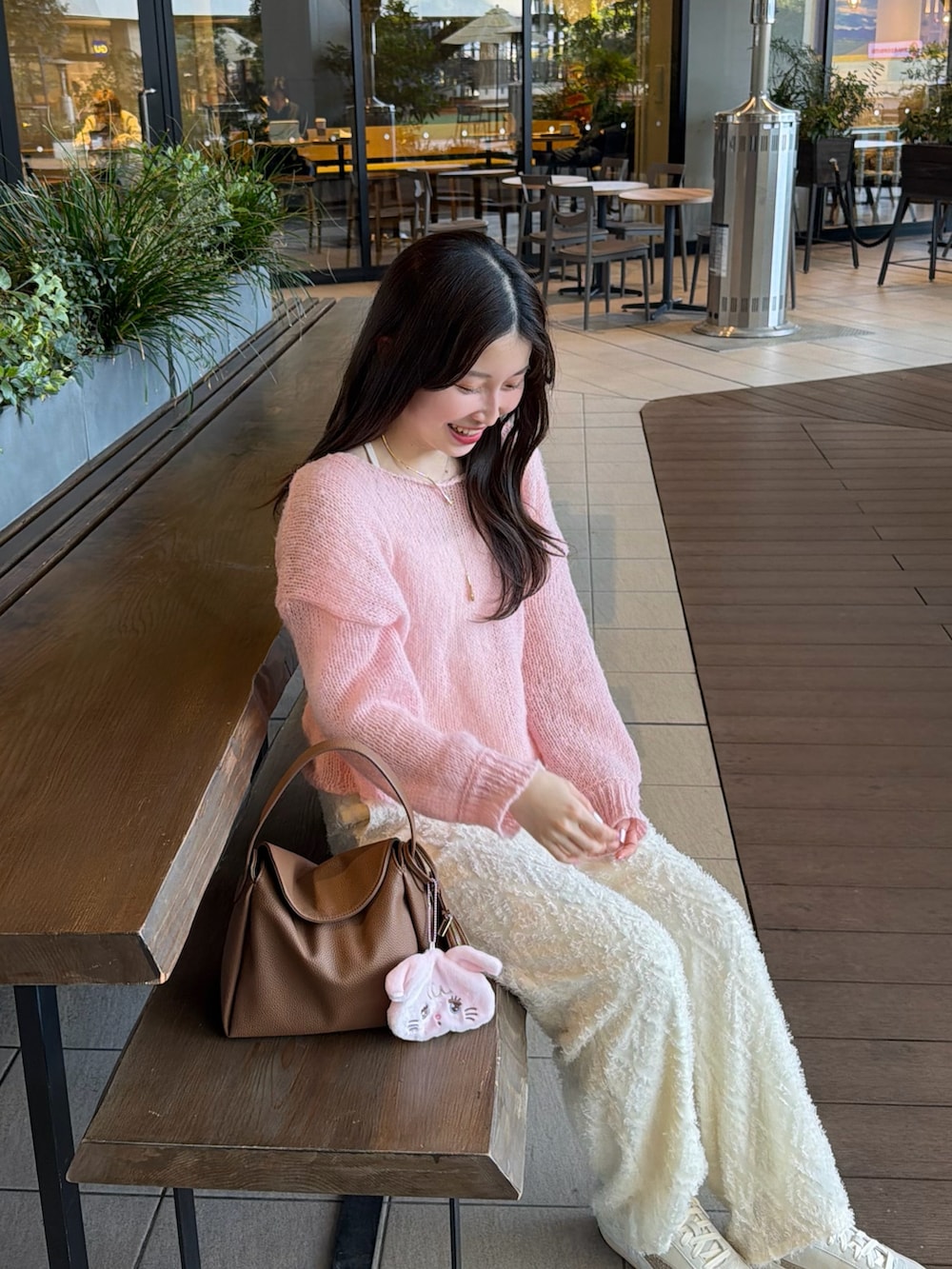 ピンク系のニット/セーター、ホワイト系のスニーカー、イエロー系のハンドバッグを着用したレディースの春コーディネートの4枚目の写真