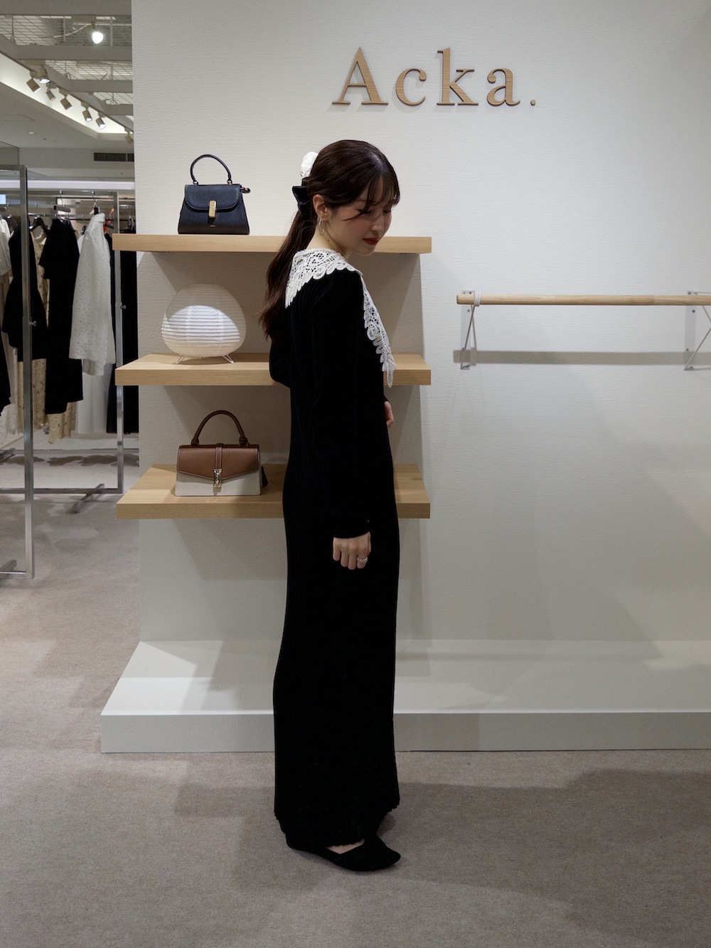 ブラック系のワンピース、ブラック系のパンプス、その他の香水を着用したレディースの春コーディネートの2枚目の写真