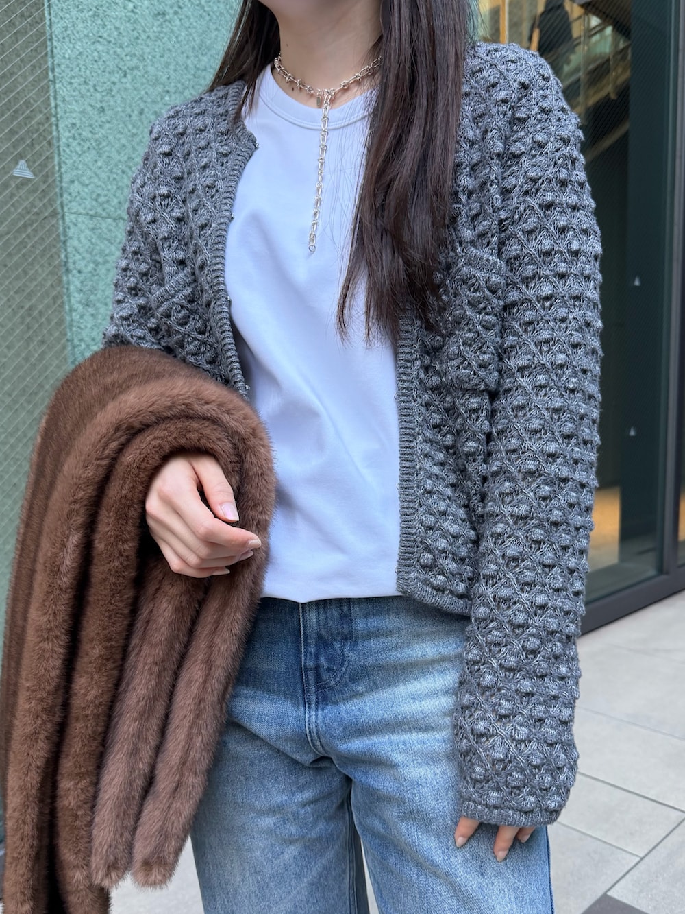 グレー系のニット/セーター、ブルー系のその他パンツ、ホワイト系のTシャツ/カットソーを着用したレディースの冬コーディネートの3枚目の写真