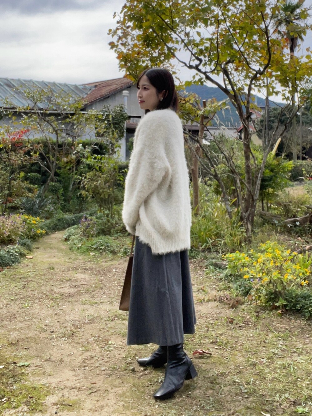 ホワイト系のニット/セーター、グレー系のワンピース、ホワイト系のカーディガン/ボレロを着用したレディースの秋コーディネートの2枚目の写真