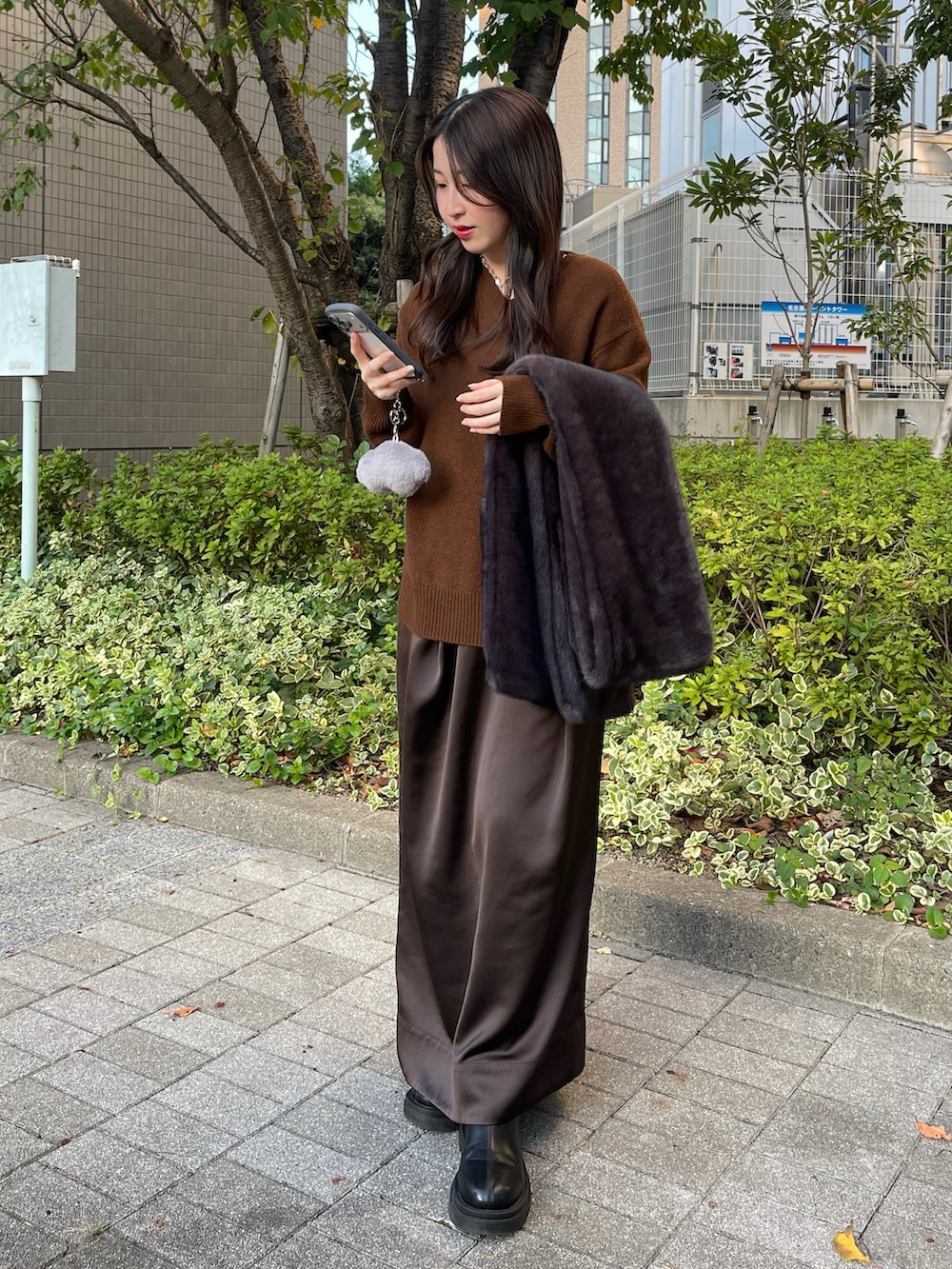 ブラック系のブーツ、ブラウン系のニット/セーター、ブラウン系のスカートを着用したレディースの秋コーディネートの4枚目の写真