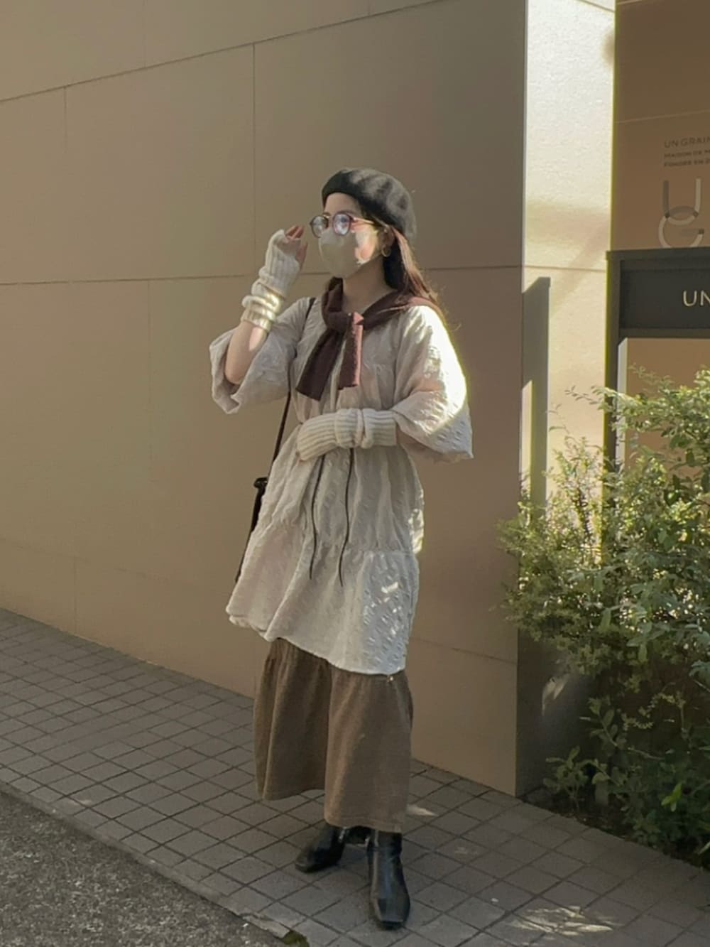 ホワイト系のワンピース、ブラウン系のニット/セーター、ブラウン系のスカートを着用したレディースの秋コーディネートの2枚目の写真