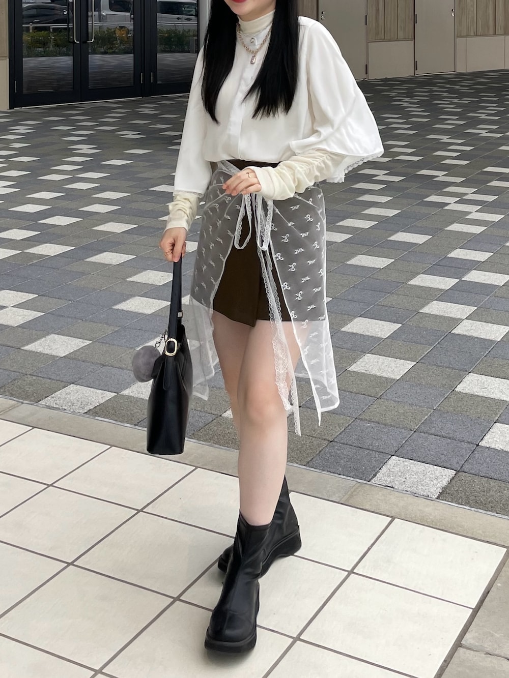 ブラック系のブーツ、ホワイト系のシャツ/ブラウス、ホワイト系のTシャツ/カットソーを着用したレディースの秋コーディネートの3枚目の写真