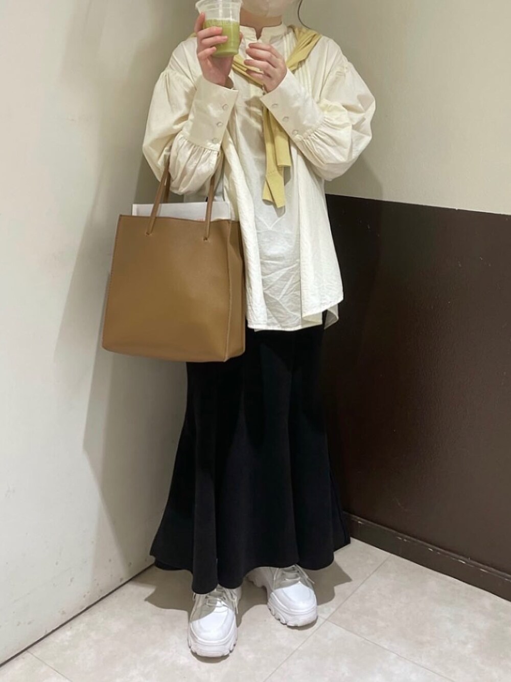 ホワイト系のシャツ/ブラウス、イエロー系のカーディガン/ボレロ、ブラック系のスカートを着用したレディースの春コーディネートの4枚目の写真