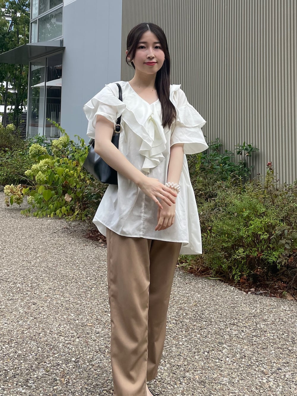 ホワイト系のシャツ/ブラウス、ベージュ系のその他パンツ、ブラック系のハンドバッグを着用したレディースの秋コーディネートの2枚目の写真