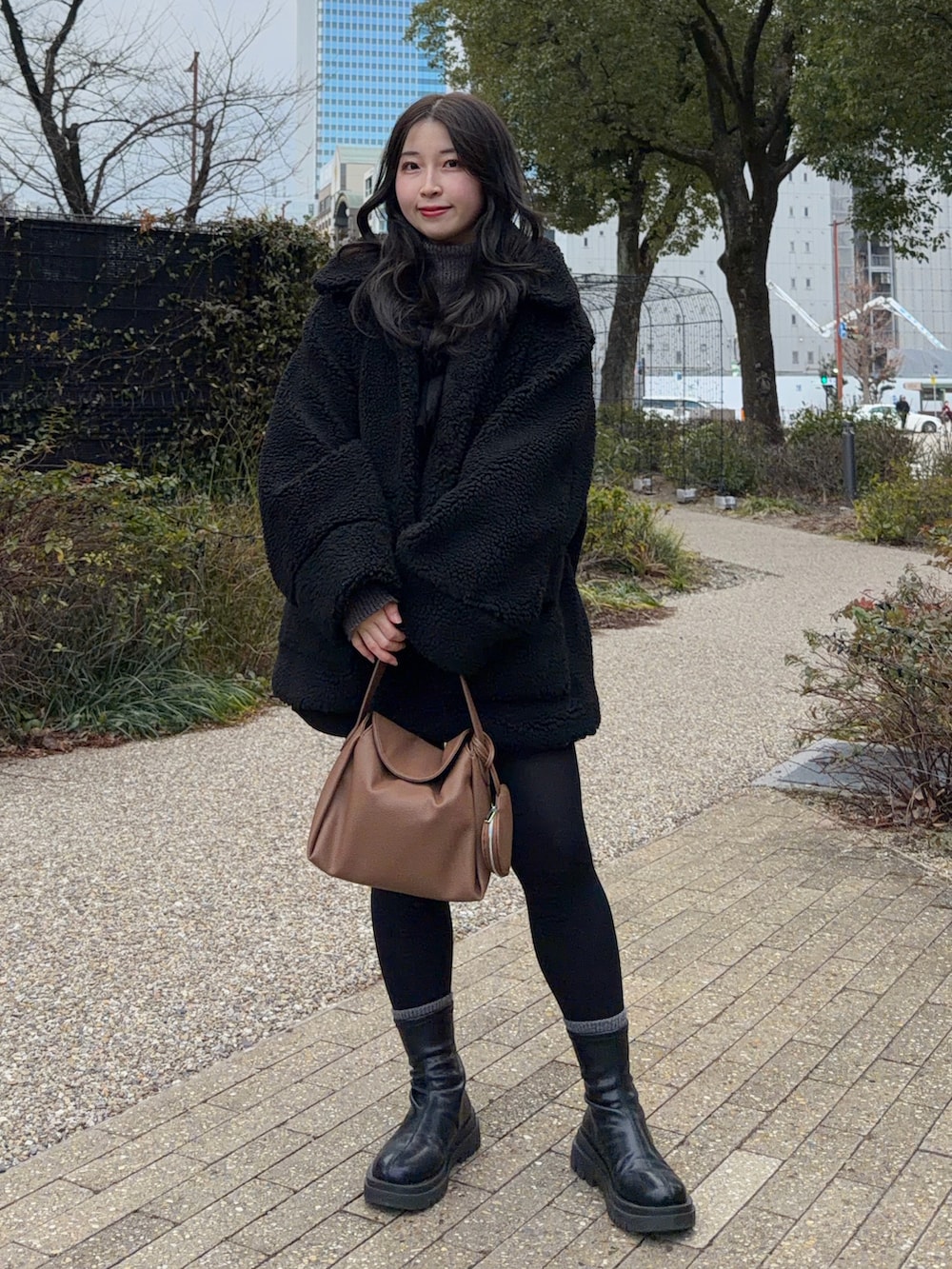 ブラック系のその他アウター、ブラック系のその他パンツ、ブラック系のブーツを着用したレディースの冬コーディネートの4枚目の写真