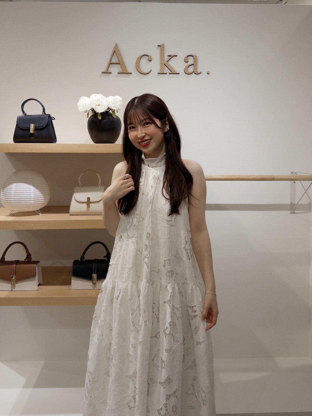 ホワイト系のワンピース/ドレス、ブラック系のパンプス、その他の香水を着用したレディースの春コーディネートの3枚目の写真