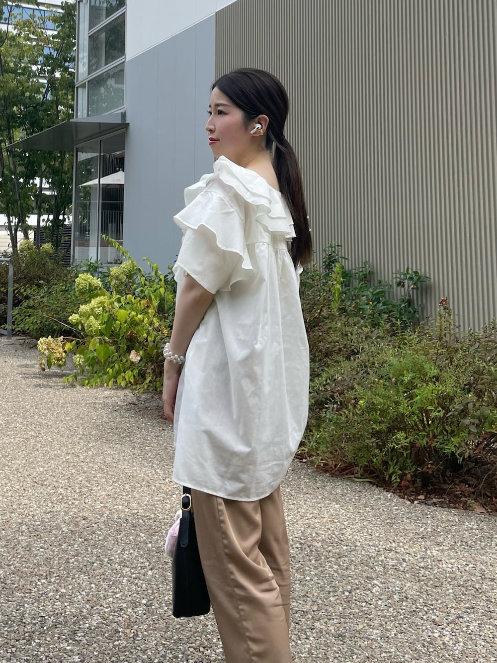 ホワイト系のシャツ/ブラウス、ベージュ系のその他パンツ、ブラック系のハンドバッグを着用したレディースの秋コーディネートの3枚目の写真